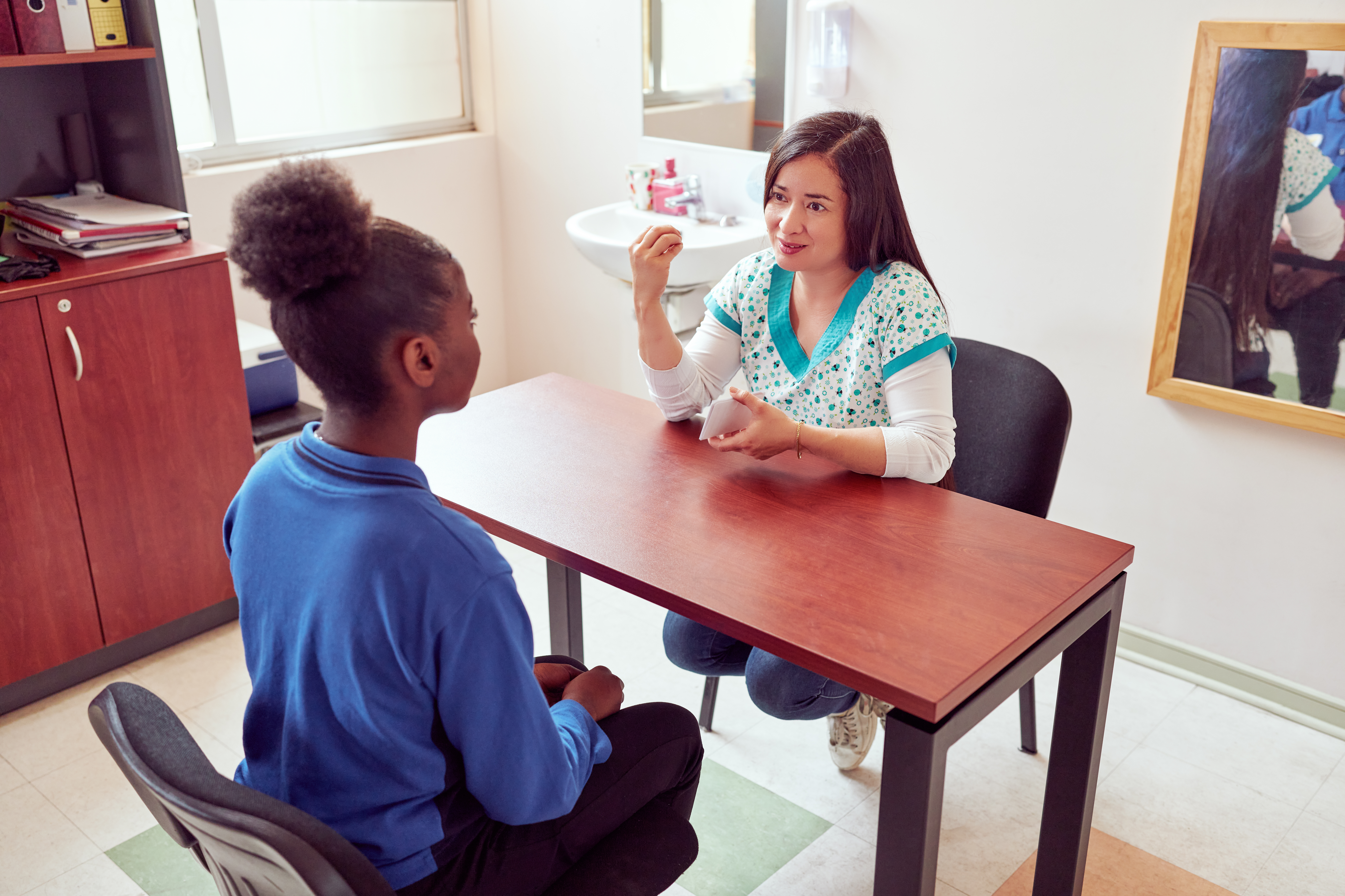 speech therapist working with playing cards with black teenage s